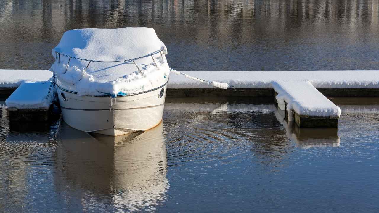 a boat covered with snow in a lake