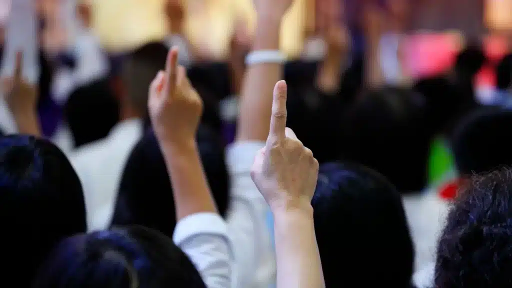 Person raising their finger at an auction